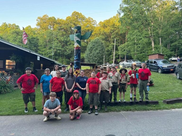 Scouts and leaders lined up outside a camp lodge